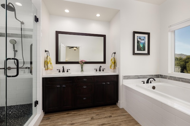 bathroom with shower with separate bathtub, vanity, and hardwood / wood-style flooring