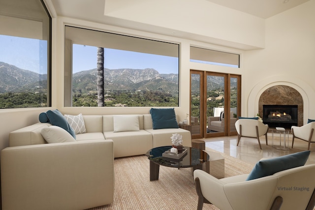 living room with a mountain view, light tile patterned floors, and a tile fireplace