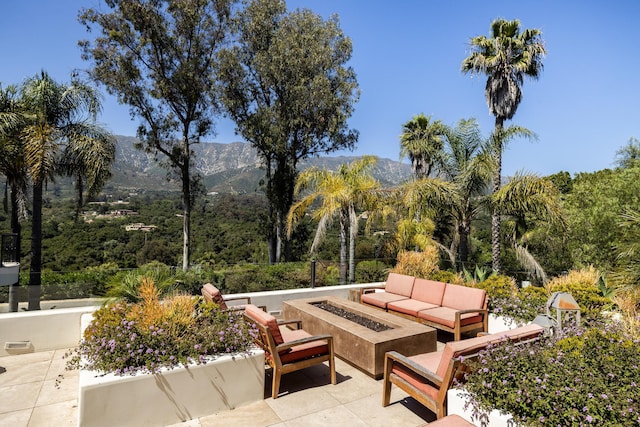 view of patio / terrace featuring a mountain view and an outdoor living space with a fire pit