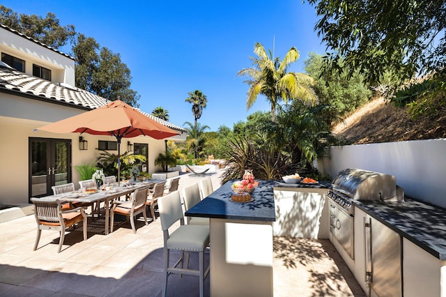 view of patio / terrace with french doors, an outdoor kitchen, and grilling area