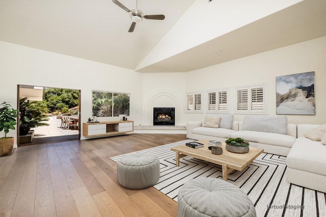 living room featuring high vaulted ceiling, light hardwood / wood-style flooring, and ceiling fan