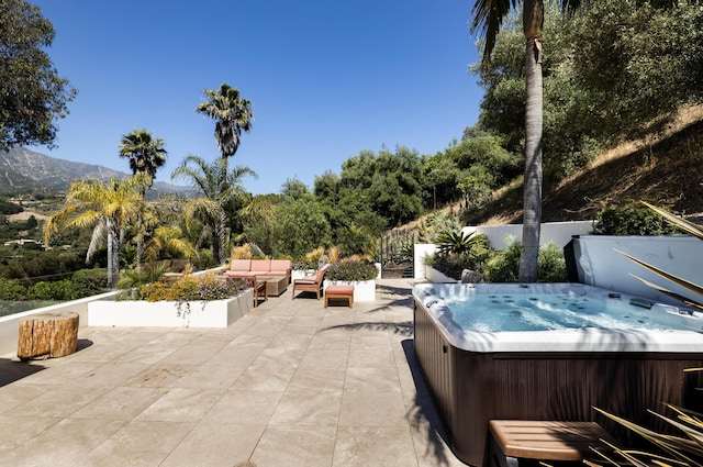 view of patio / terrace featuring a mountain view and a hot tub