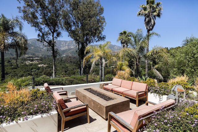 view of patio / terrace with a mountain view and an outdoor living space with a fire pit