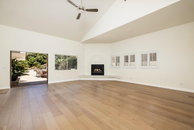 unfurnished living room with high vaulted ceiling, light hardwood / wood-style flooring, and ceiling fan