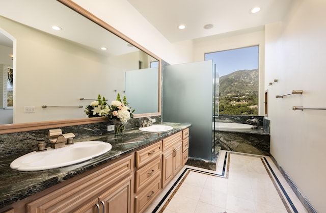 bathroom featuring tile patterned flooring, vanity, a mountain view, and a tub to relax in