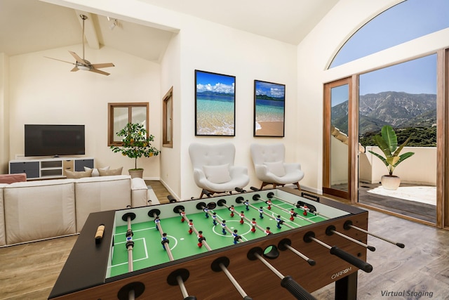 game room featuring beam ceiling, a mountain view, ceiling fan, and light hardwood / wood-style floors