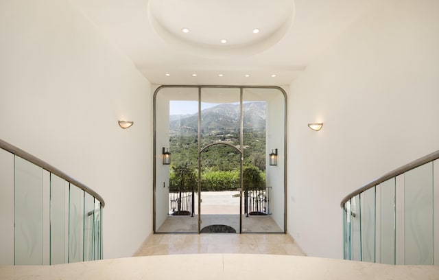 foyer entrance featuring a tray ceiling and a mountain view