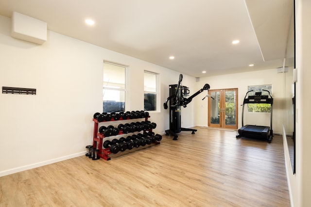 workout room with french doors and light wood-type flooring