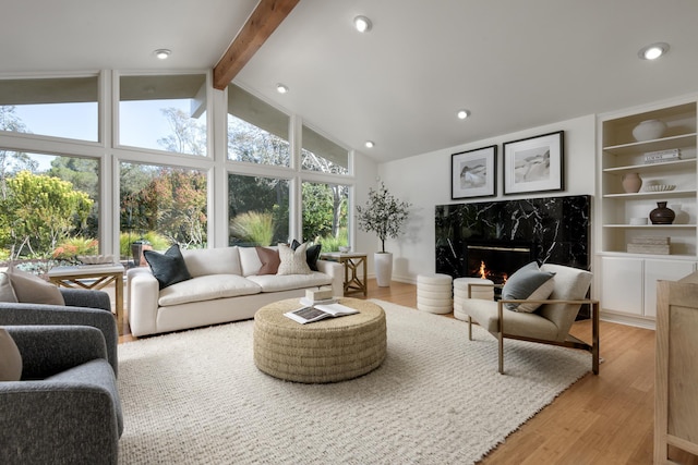 sunroom with lofted ceiling with beams and a fireplace