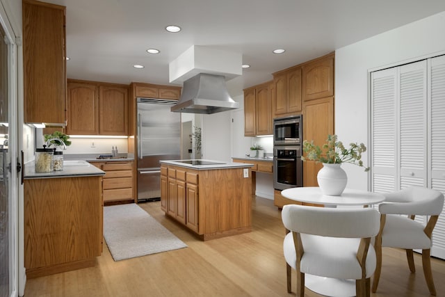 kitchen with light wood finished floors, a center island, built in appliances, island exhaust hood, and recessed lighting