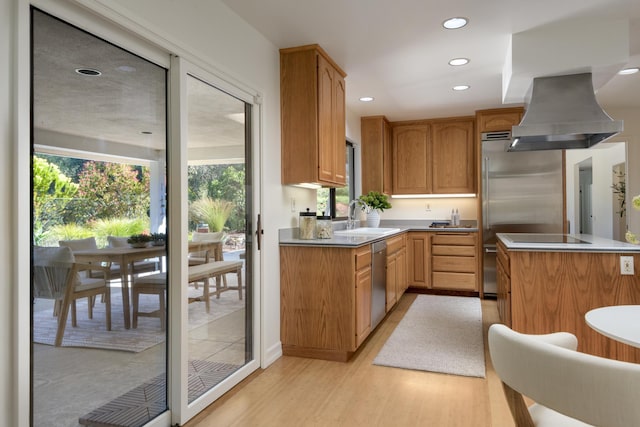 kitchen featuring dishwasher, a sink, island exhaust hood, and a healthy amount of sunlight