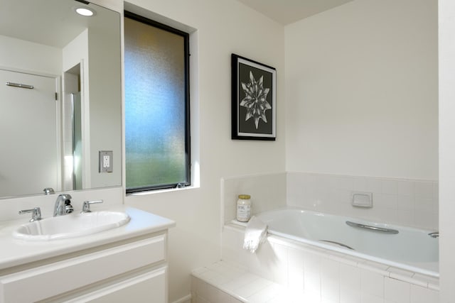 full bath featuring a garden tub and vanity