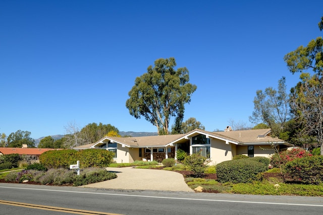 view of front facade with a chimney and stucco siding