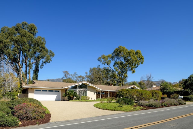 view of front facade with driveway, an attached garage, and stucco siding