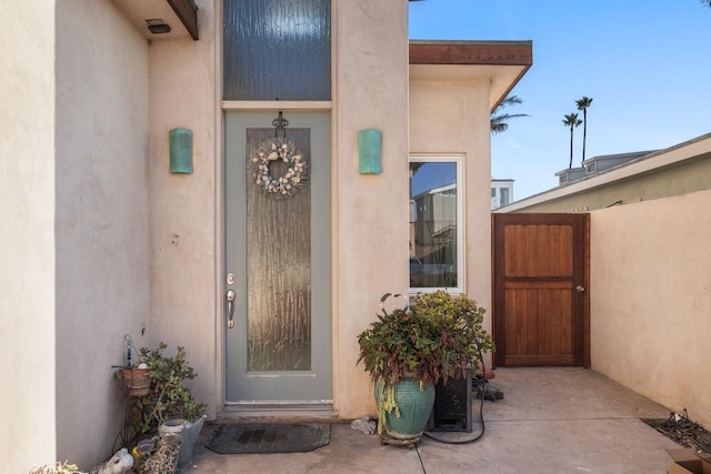 entrance to property featuring stucco siding