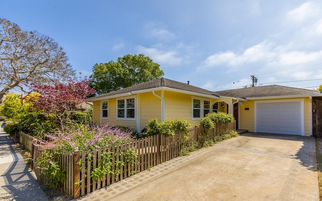 view of front of property featuring roof with shingles, an attached garage, concrete driveway, and fence