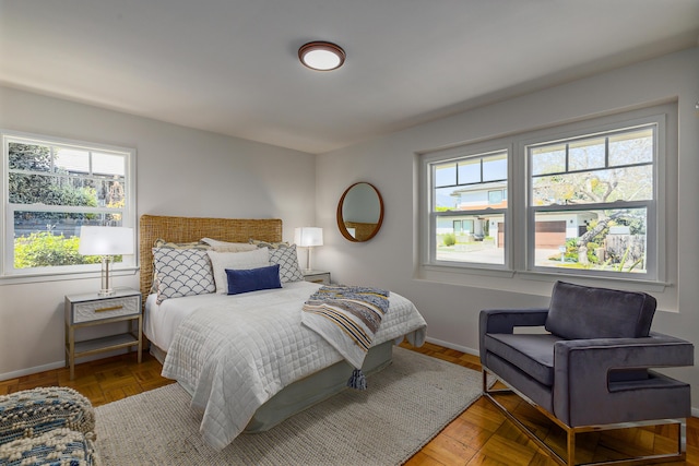 bedroom with baseboards and multiple windows