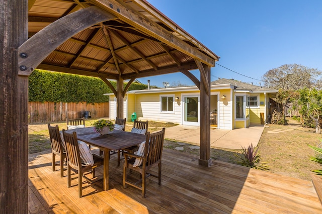wooden deck featuring a gazebo, fence, and outdoor dining space
