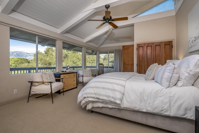 bedroom with lofted ceiling with beams, multiple windows, carpet, and baseboards