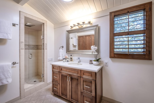 bathroom with baseboards, vaulted ceiling, a shower stall, and vanity