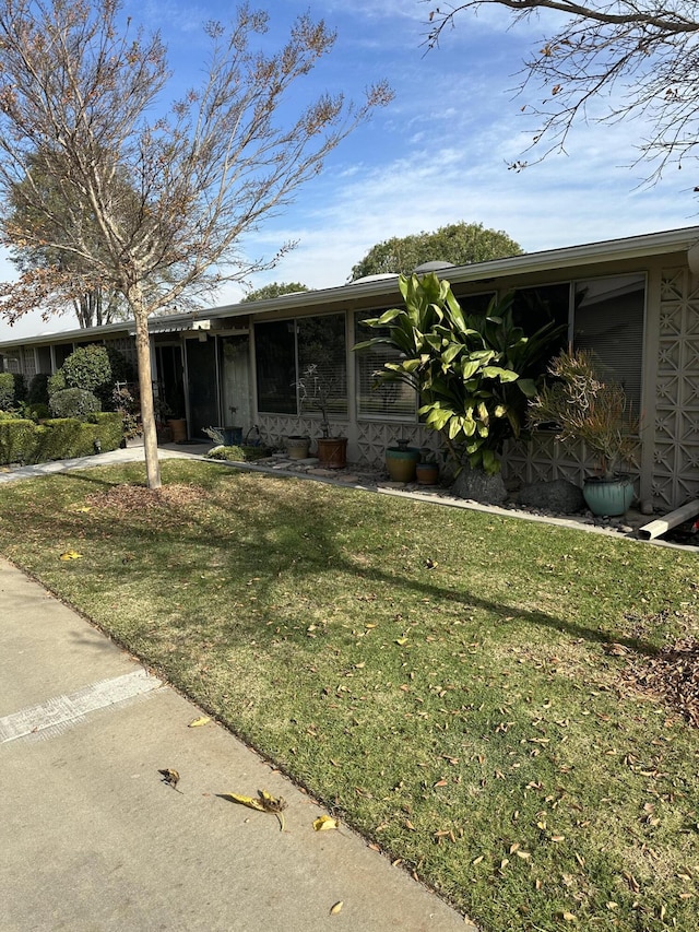 view of front of house with a front yard and a sunroom