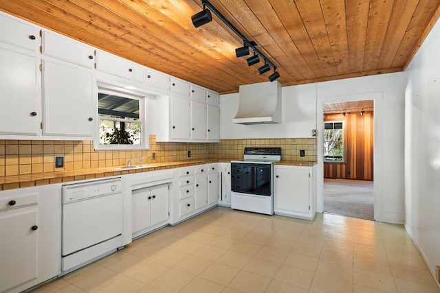 kitchen featuring plenty of natural light, rail lighting, exhaust hood, and white appliances