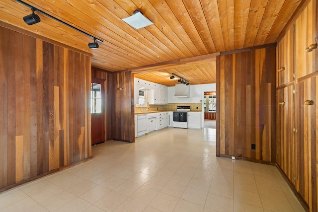 kitchen with white appliances, white cabinets, rail lighting, wooden walls, and wood ceiling