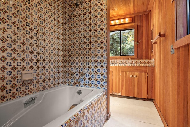 bathroom featuring tile patterned floors, a washtub, wooden ceiling, and wooden walls