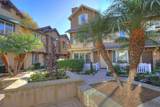 view of front facade featuring fence and stucco siding