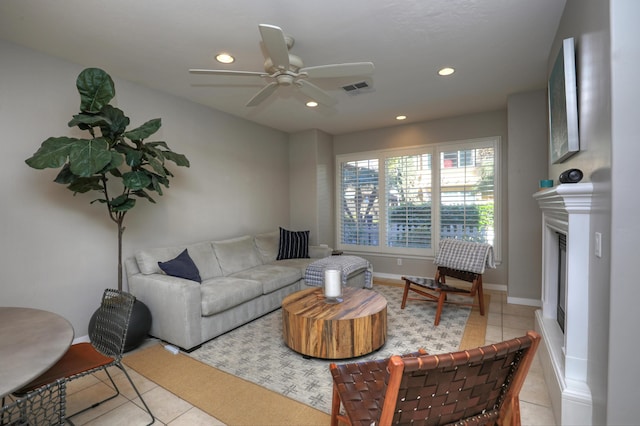 living area featuring light tile patterned floors, recessed lighting, visible vents, a glass covered fireplace, and baseboards