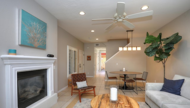 living room with light tile patterned flooring, a glass covered fireplace, visible vents, and recessed lighting