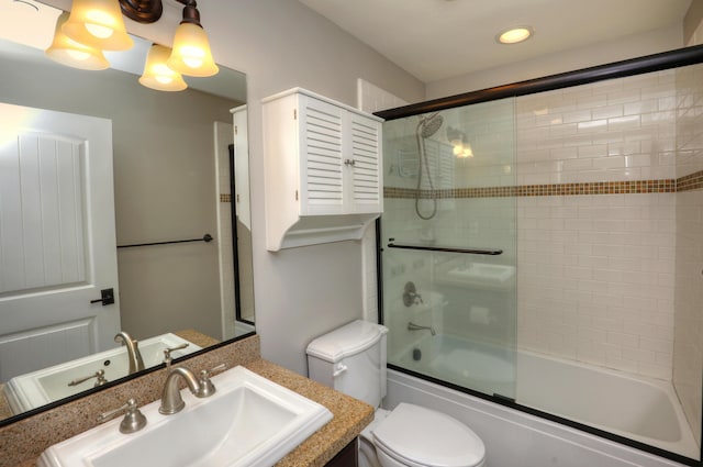 full bathroom featuring vanity, enclosed tub / shower combo, and toilet