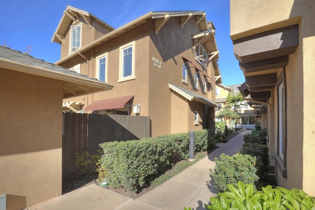 view of property exterior featuring fence and stucco siding