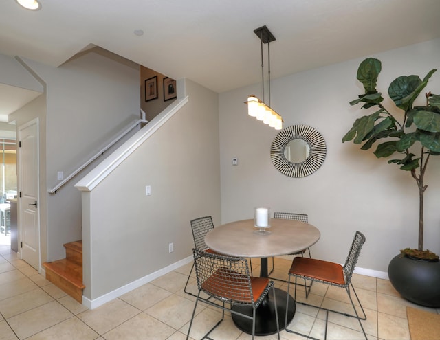 dining room with stairway, light tile patterned flooring, and baseboards