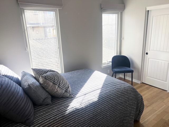 bedroom with light wood-style flooring and baseboards