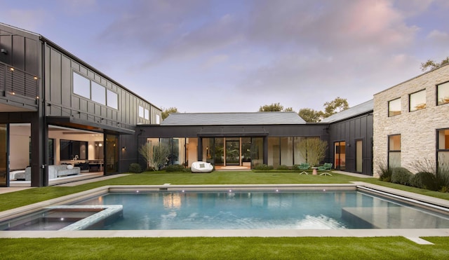 view of pool featuring an in ground hot tub and a lawn