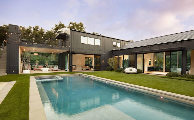 rear view of house featuring an outdoor hangout area, a balcony, a lawn, and a patio