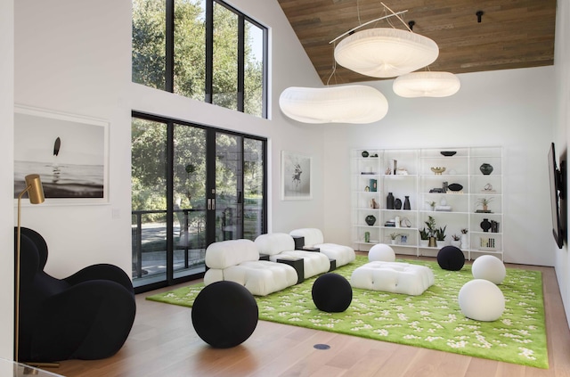 workout room featuring wooden ceiling, hardwood / wood-style flooring, and high vaulted ceiling