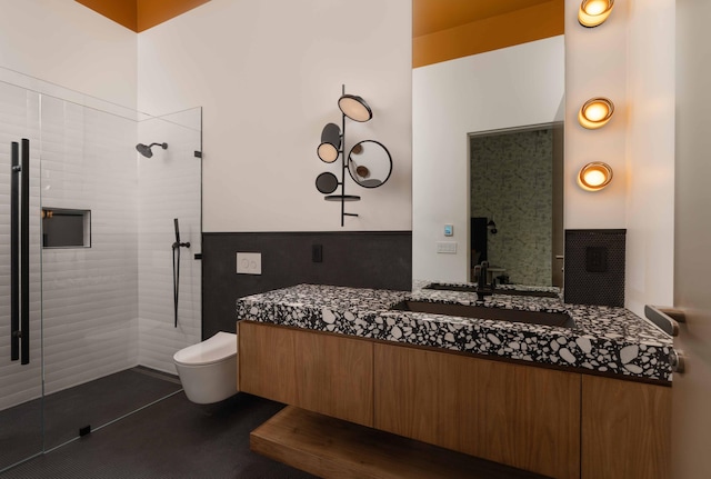 bathroom with toilet, vanity, and tiled shower