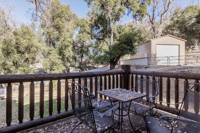 wooden terrace featuring an outdoor structure and a garage