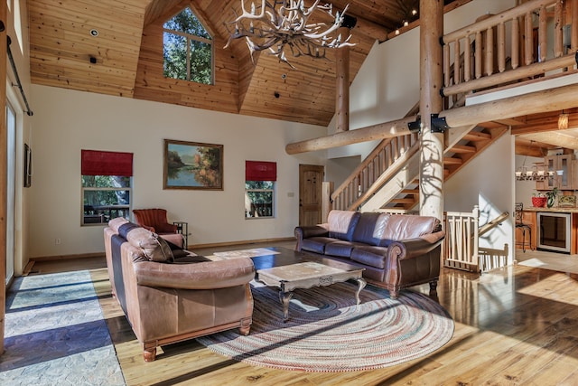 living room featuring beam ceiling, high vaulted ceiling, a chandelier, wood ceiling, and hardwood / wood-style flooring