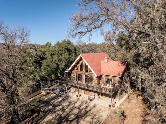 back of house featuring a garage and a wooden deck