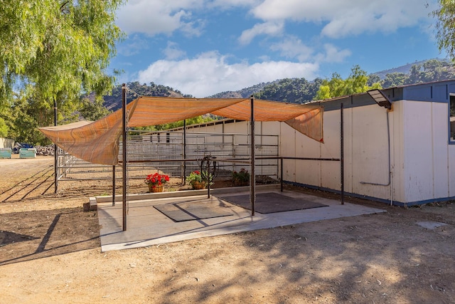 view of patio / terrace featuring a mountain view and an outbuilding