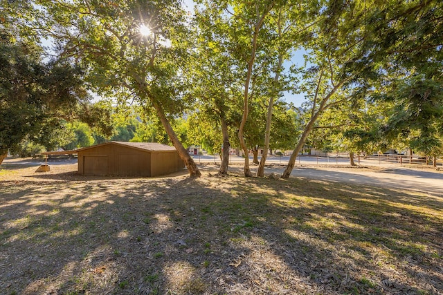 view of yard with a rural view and an outdoor structure