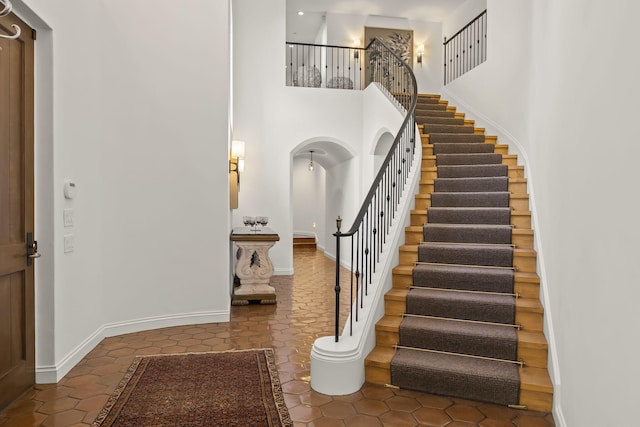 tiled foyer entrance with a towering ceiling