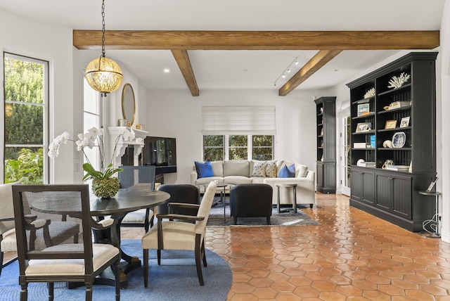 dining space with beamed ceiling and a wealth of natural light