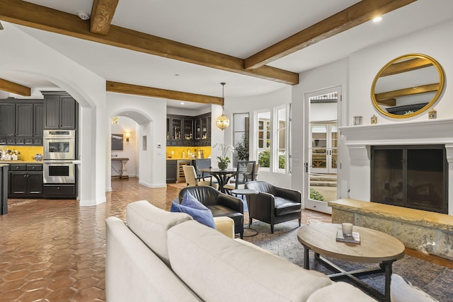 living room featuring beam ceiling and dark tile patterned floors