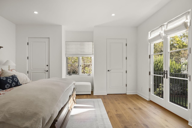 bedroom with access to exterior, french doors, and light hardwood / wood-style floors