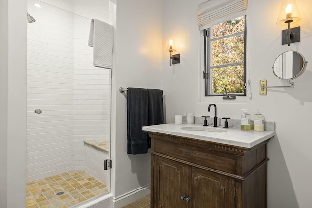 bathroom with tiled shower and vanity