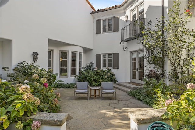 view of patio with a balcony and french doors